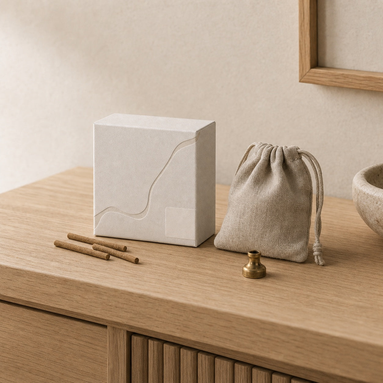 Unlabelled white incense box with brown incense sticks beside a fabric pouch