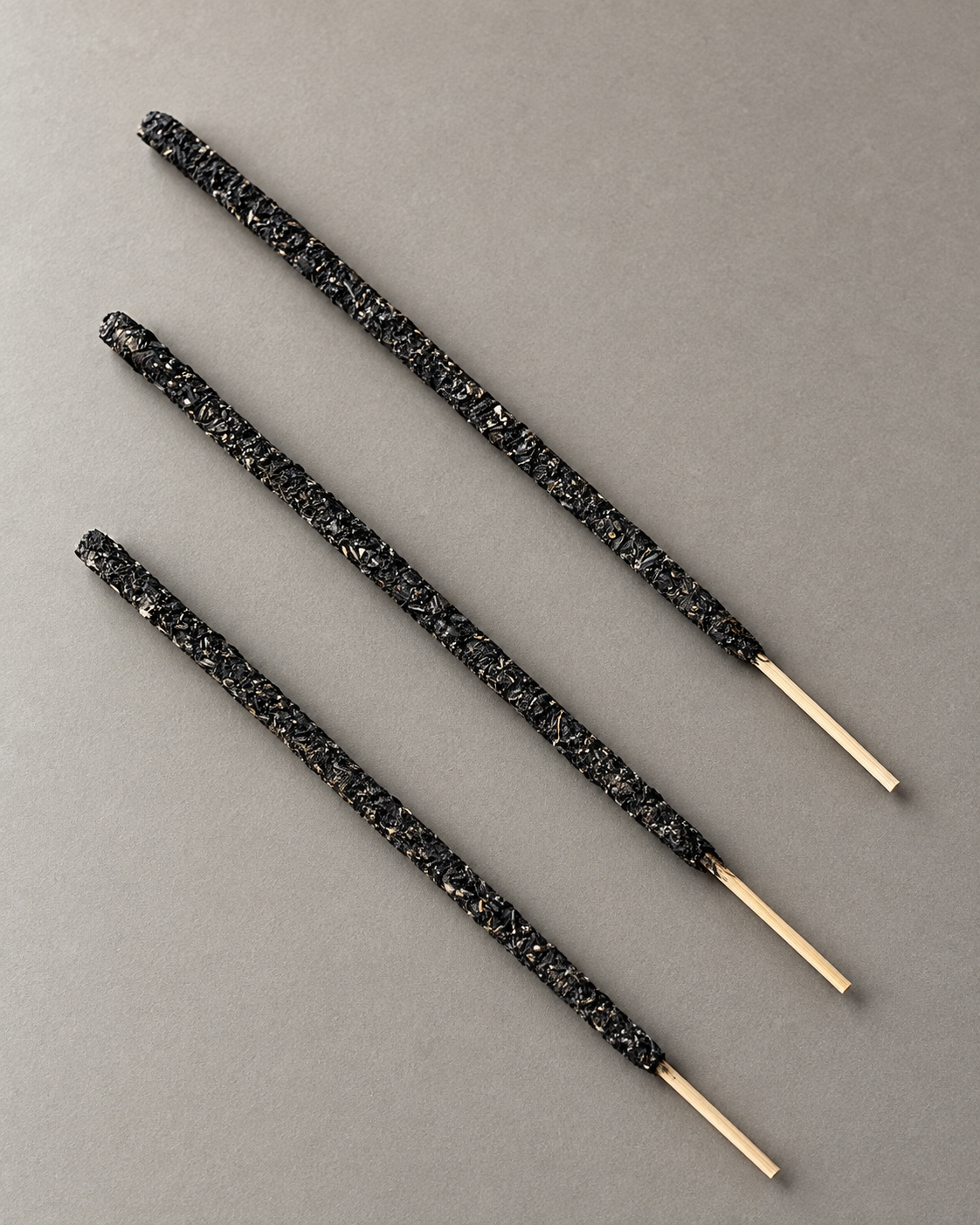 Three representative yagra incense sticks showing the full incense body and bamboo handles.