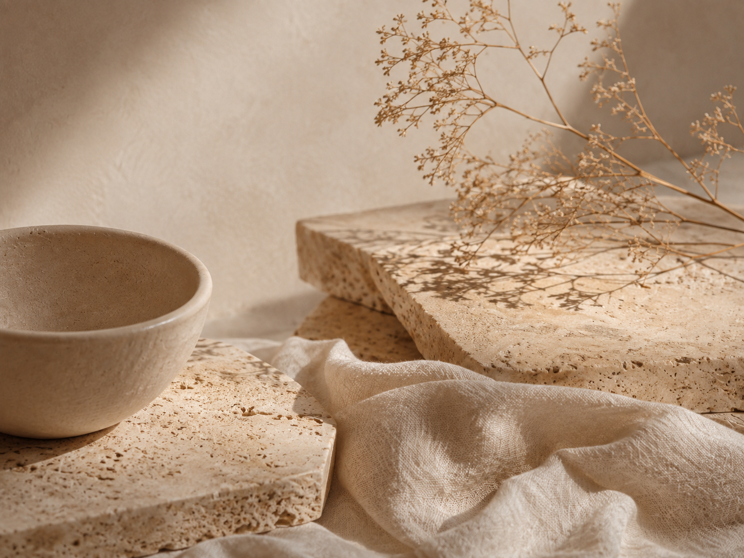 Warm beige abstract still life with stone, linen, dried botanicals and soft natural light