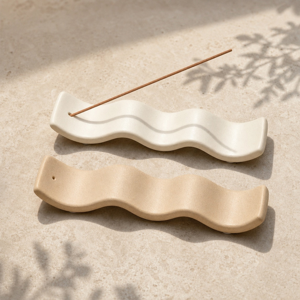 White and sand wave-shaped incense holders displayed together; colour reference image