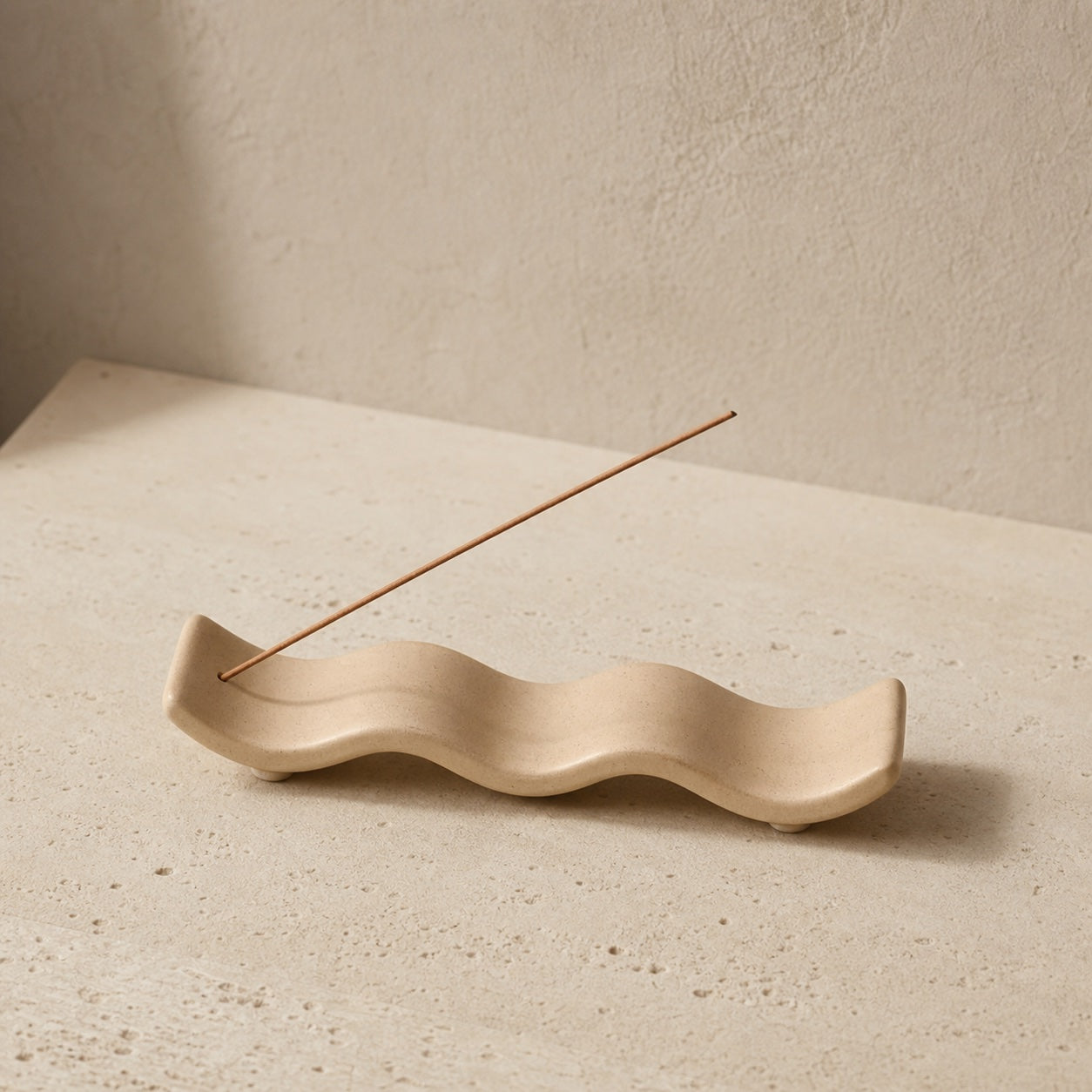 Sand-coloured wave-shaped incense holder with one incense stick; colour reference image